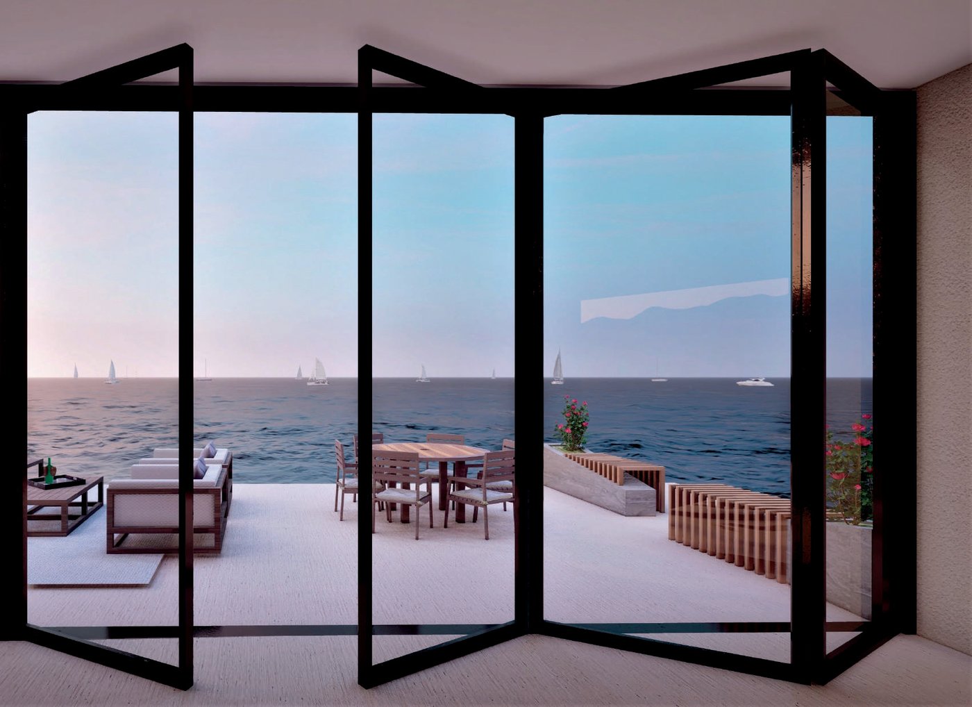 Folding aluminum glass doors opened onto a sea-facing terrace at dusk